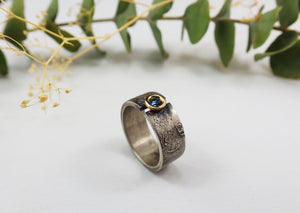 Anillo de plata con textura, oro de 18 kt y topacio azul