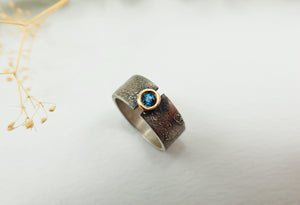 Anillo de plata con textura, oro de 18 kt y topacio azul