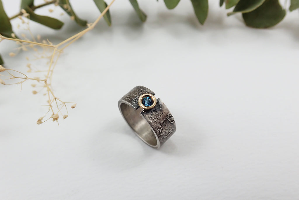 Anillo de plata con textura, oro de 18 kt y topacio azul