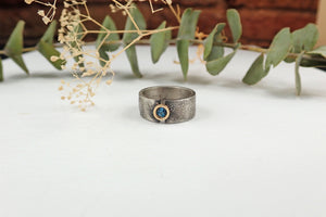 Anillo de plata con textura, oro de 18 kt y topacio azul