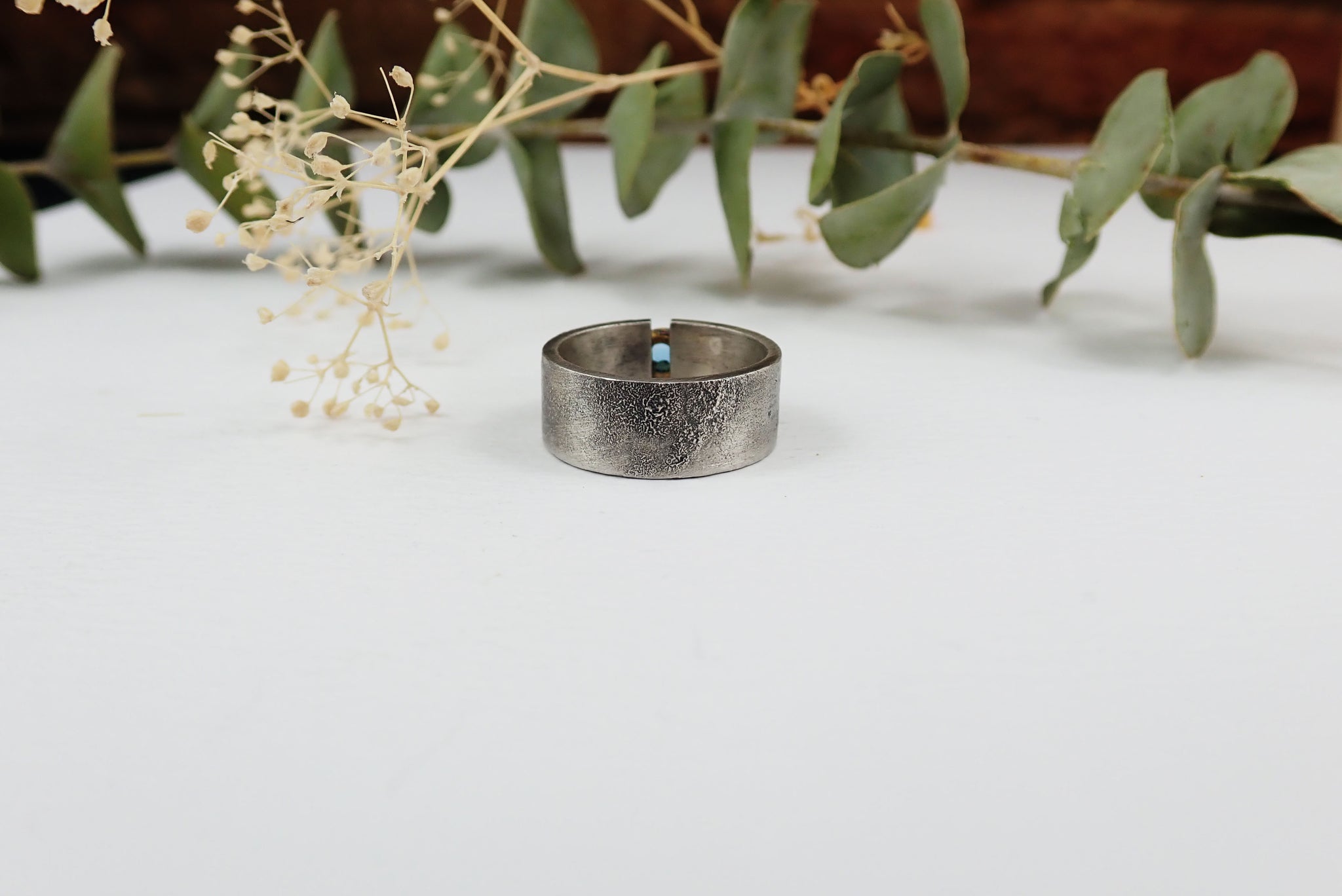 Anillo de plata con textura, oro de 18 kt y topacio azul