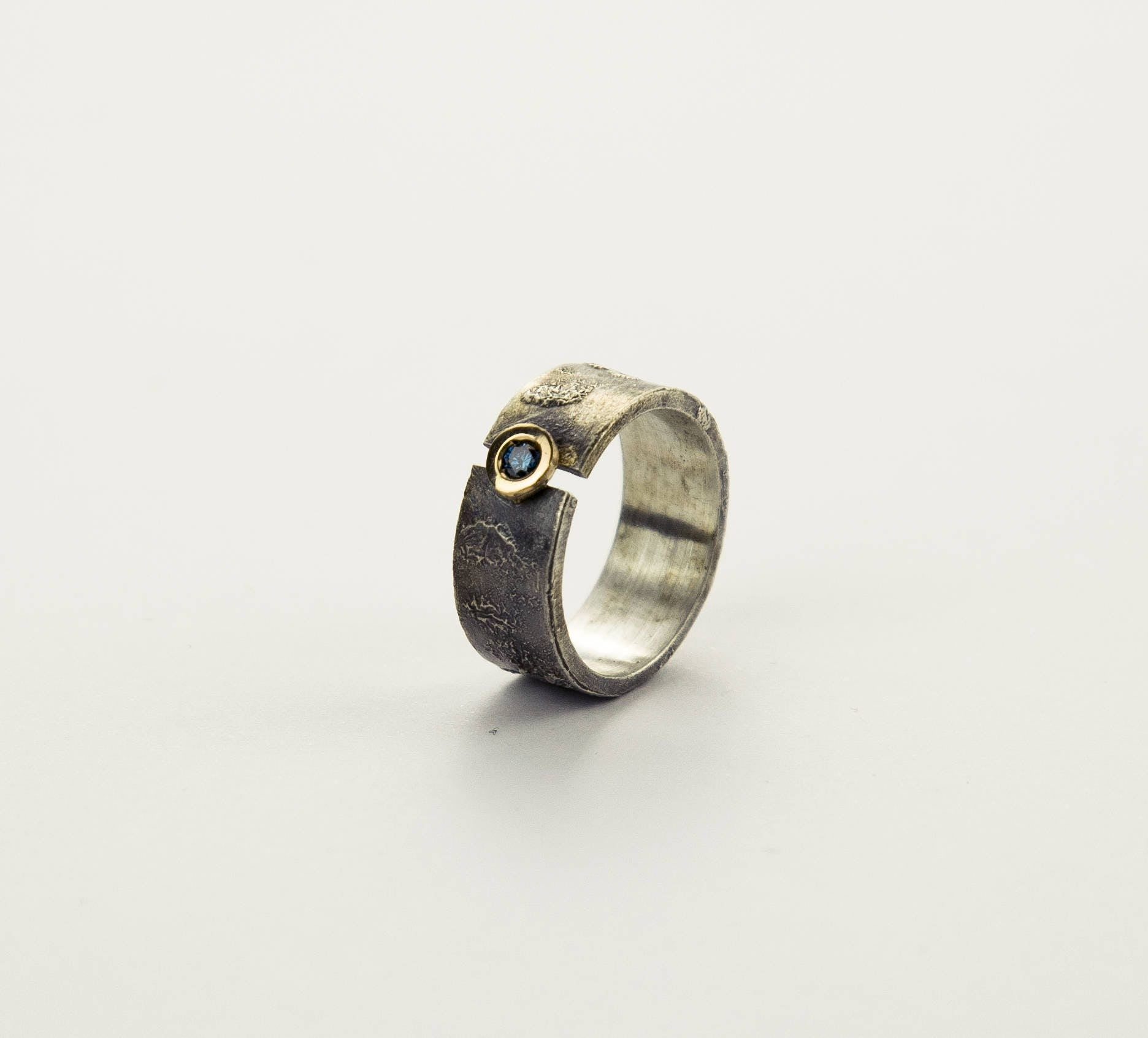 Anillo de plata con textura, oro de 18 kt y diamante azul